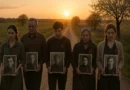 Участники Бессмертного полка несут портреты своих героев на фоне заходящего солнца